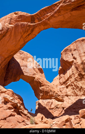 Escursionista si fermò in un arco a doppia arcata Arches National Park, vicino a Moab, Utah Stati Uniti d'America, STATI UNITI D'AMERICA Foto Stock