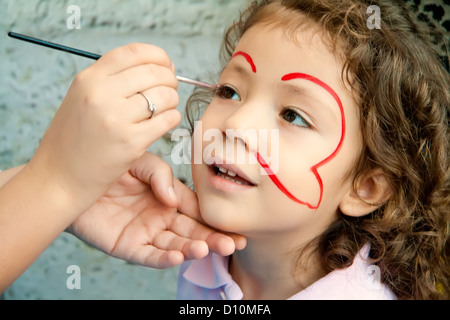 Bambina ottenendo il suo volto dipinto Foto Stock