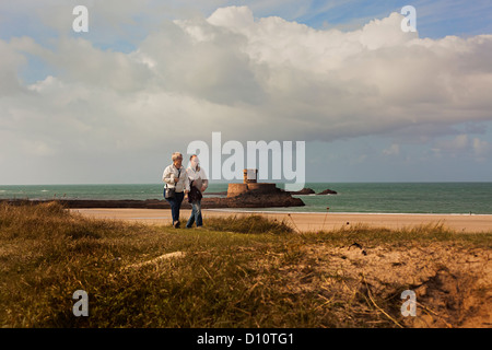 Giovane camminando nelle dune di sabbia passato La Rocco o Gordon's Tower St Ouen's Bay Jersey REGNO UNITO Foto Stock