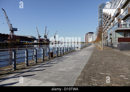 Vista Ovest lungo il fiume Clyde a BAE Systems cantiere, a sinistra e a Glasgow Harbour alloggiamento privato, diritto, Glasgow, Scotland, Regno Unito Foto Stock