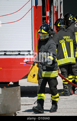 Vigili del Fuoco italiano estinguere un incendio simulato durante un esercizio di loro Firehouse Foto Stock