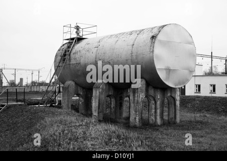 Vecchio serbatoio e rusty scala sul gas-stazioni di riempimento Foto Stock