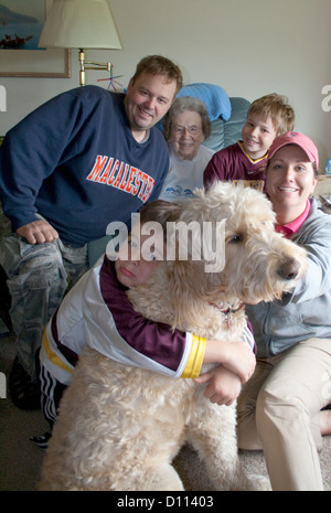Grande nonna età 95 godendo di tre o quattro generazioni e Gunnar la famiglia Goldendoodle cane battaglia Lago Minnesota MN USA Foto Stock