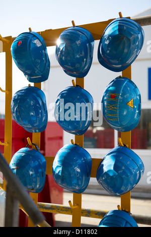 Blue hardhats appeso sul sito di costruzione. Foto Stock