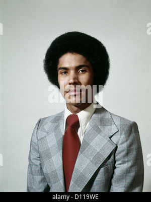 Anni Settanta in testa e la spalla ritratto di afro-americano con taglio di capelli afro e la moda di volte indossare giacca e cravatta Foto Stock