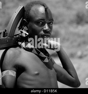 Ritratto in bianco e nero di una banna tribù Guerriero con kalashnikov, Valle dell'Omo, Etiopia Foto Stock