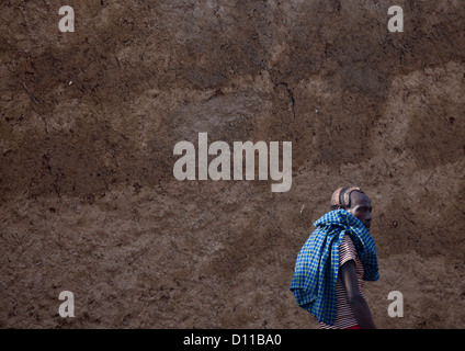 Hamar Tribe Uomo passando da un muro di fango, Turmi, Valle dell'Omo, Etiopia Foto Stock