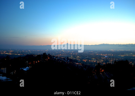 Una vista della città di Torino dal Parco Europa park con le Alpi ed il Monte Monviso sullo sfondo durante il tramonto. Foto Stock