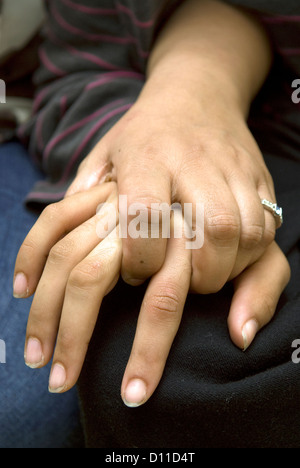 Madre tenendo la mano di 24 anni, figlia che soffre di paralisi cerebrale, Londra, Regno Unito. Modello rilasciato. Foto Stock