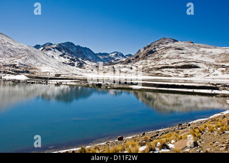 Paesaggi innevati e calme acque blu del lago nelle Ande montagne vicino la città di Potosi Bolivia America del Sud Foto Stock