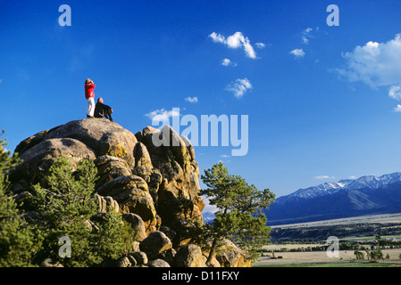 Anni ottanta anziana coppia escursionismo stando seduti sulle rocce godendo della vista Foto Stock