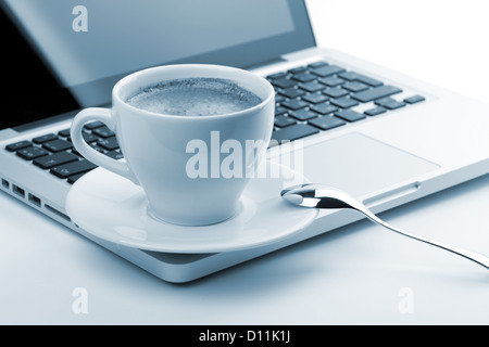 Tazza cappuccino sul laptop. Piccolo DOF, nei toni del blu Foto Stock