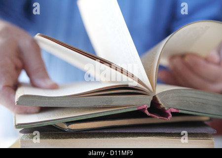 Un uomo capovolge attraverso le pagine di un libro Foto Stock