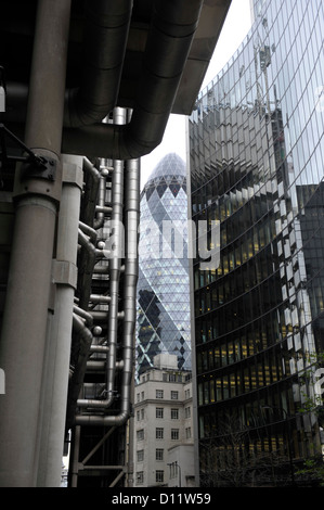 Swiss Tower, talvolta noto come il Gherkin building, nella city di Londra, con il lloyds building in primo piano. Foto Stock