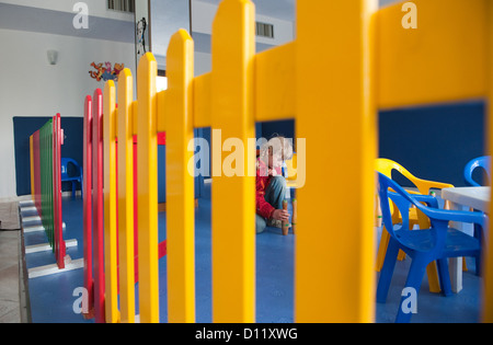 Un bambino di 3 anni in una T-shirt a righe apre una finestra, gioca in una  casa giocattolo in un centro per bambini. Zona giochi, sviluppo bambini  Foto stock - Alamy