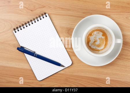 Vuoto con Blocco note e penna vuota tazza di caffè sul tavolo di legno Foto Stock