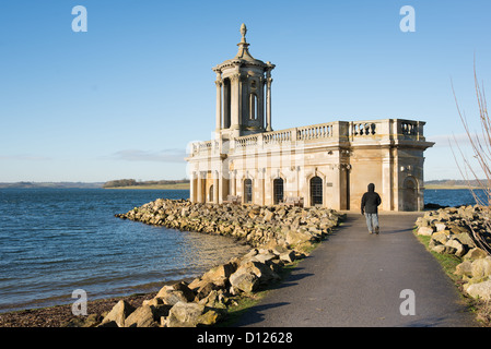 Inverno rambler passeggiate lungo il percorso di una chiesa in disuso immerso in un serbatoio. Foto Stock