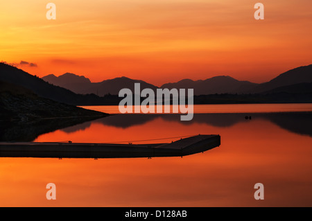 Loch Leven nelle Highlands della Scozia vicino a Glencoe. Un bellissimo tramonto con un molo in primo piano e le montagne scozzesi Foto Stock