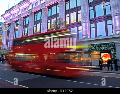 Spostando il bus di fronte dal grande magazzino Selfridges di notte, Oxford Street, City of Westminster, Londra, Inghilterra, Regno Unito Foto Stock