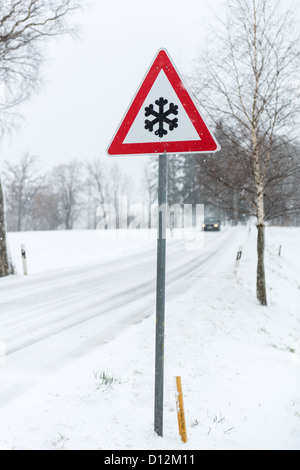 Cartello stradale accanto alla strada invernale in Baviera/Germania Foto Stock