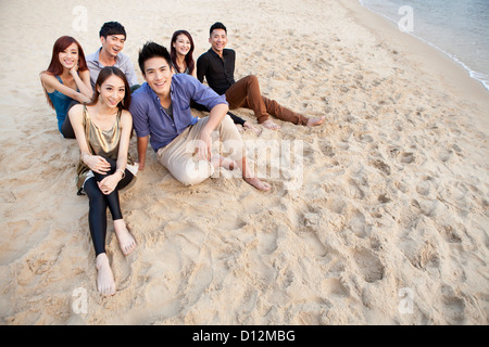 Felice giovani seduto sulla spiaggia di Repulse Bay, guardando a vista, Hong Kong Foto Stock