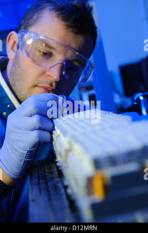 Scienziato esamina micro tubi di prova pronto per l'immissione in una centrifuga nel laboratorio di scienze Foto Stock