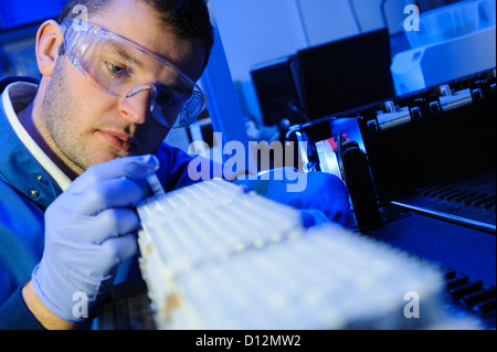 Scienziato esamina micro tubi di prova pronto per l'immissione in una centrifuga nel laboratorio di scienze Foto Stock