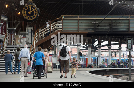 La gente camminare lungo una piattaforma presso la stazione ferroviaria di York, Inghilterra. Foto Stock