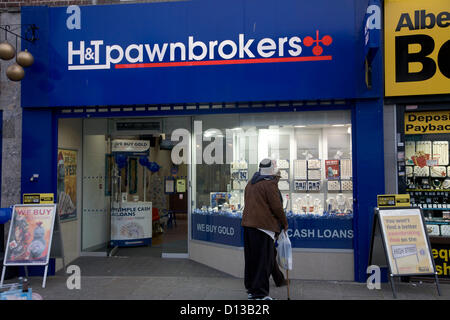 Il 6 dicembre 2012. Londra REGNO UNITO. Gli acquirenti di stand al di fuori di un negozio pawnbroker a Lewisham. Il cancelliere dello scacchiere britannico è stato costretto ad ammettere che l'economia del Regno Unito si restringerà ulteriormente durante il suo autunno dichiarazione di bilancio al Parlamento europeo e una ripresa economica richiederà più tempo del previsto Foto Stock