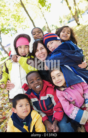 Multi-Ethnic nuovi bambini canadesi abbraccio il loro insegnante al di fuori della scuola Esl; Guelph Ontario Canada Foto Stock