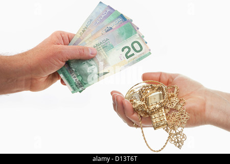 Stretta di mano lo scambio di banconote e gioielli in oro, studio shot Foto Stock
