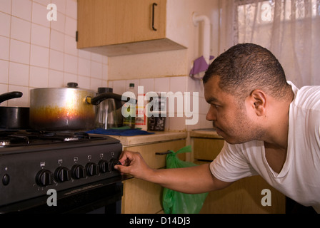 Il marito che si prende cura di sua moglie disabili a casa a preparare il pranzo per loro sia in cucina, Londra, Regno Unito. Modello rilasciato l'immagine. Foto Stock