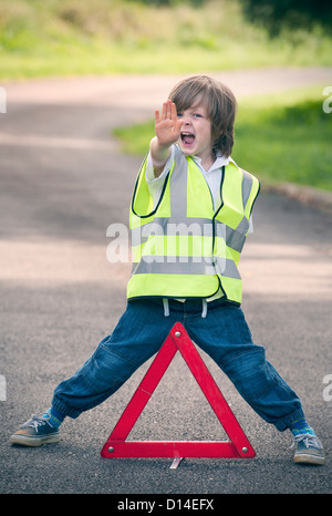 Ragazzo giocando lavoratore del traffico su strada rurale Foto Stock