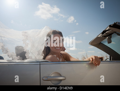 Sposa giovane la guida nel convertibile Foto Stock