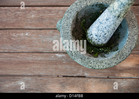 Le erbe in massa nel pestello e mortaio Foto Stock