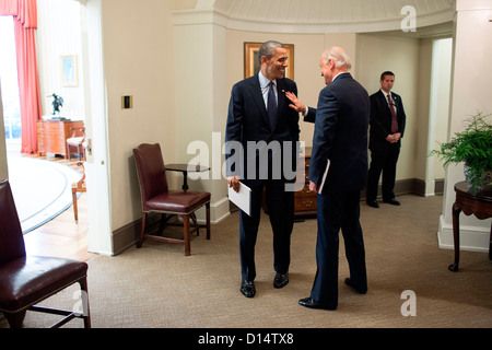 Il Presidente Usa Barack Obama i colloqui con il Vice Presidente Joe Biden nel corridoio al di fuori dell'Ufficio ovale a seguito di una riunione svoltasi il 26 novembre 2012 a Washington, DC. Foto Stock