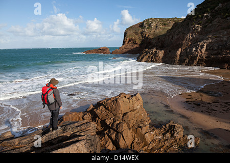 Persona in piedi sulle rocce a Plemont beach, New Jersey; Isole del Canale, REGNO UNITO Foto Stock