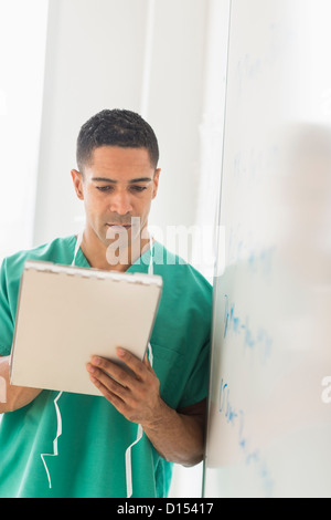 Stati Uniti d'America, New Jersey, Jersey City, maschio chirurgo lettura grafico medico in ospedale Foto Stock