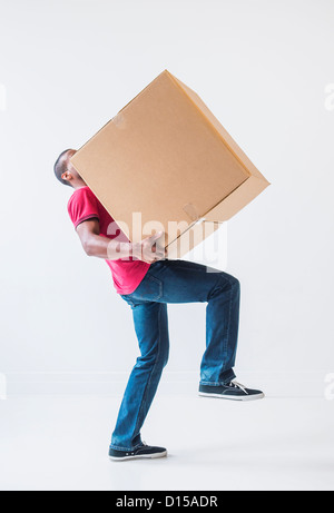 Studio shot di giovane con una grande scatola di cartone Foto Stock