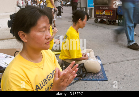 Un BUDDDHIST RISPOSTA ALLA GUERRA - Falun Gong (Falun Dafa) mediano nell'angolo di Houston Street e Broadway a New York City Foto Stock