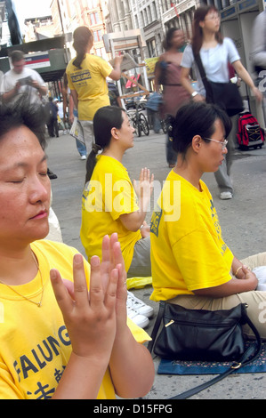 Un BUDDDHIST RISPOSTA ALLA GUERRA - Falun Gong (Falun Dafa) mediano nell'angolo di Houston Street e Broadway a New York City Foto Stock