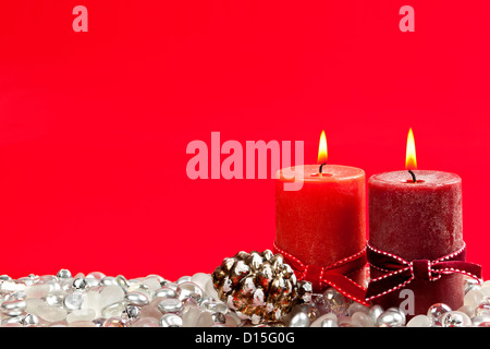 Natale candele e decorazioni su sfondo rosso Foto Stock