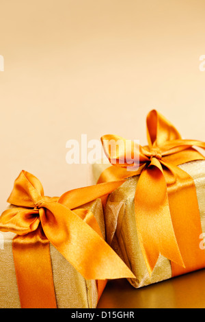 Due confezioni regalo avvolto in oro nastri con spazio di copia Foto Stock