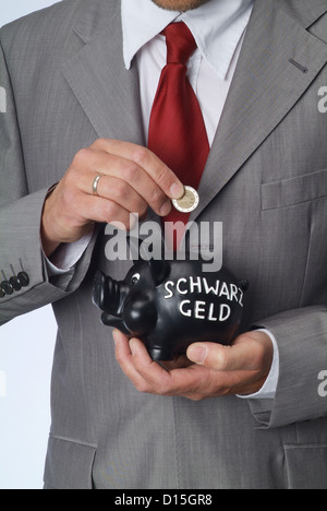 Amburgo, Germania, un uomo getta un Euromuenze denaro in un suino nero Foto Stock