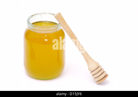 Vaso di vetro pieno di miele e stick isolato su sfondo bianco Foto Stock