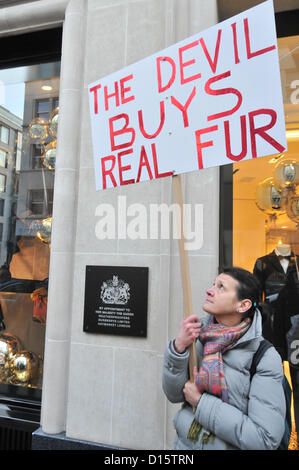 New Bond Street, Londra, Regno Unito. 8 dicembre 2012. Un manifestante CAFT detiene una targhetta vicino a 'da Royal appuntamento" cartello fuori Burberry su New Bond Street. La "campagna contro il commercio di pellicce, [CAFT]' group stage una protesta al di fuori del negozio Burberry su New Bond Street contro la vendita di pellicce. Foto Stock