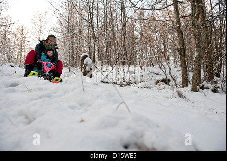 La madre e il bambino che va in discesa su una slitta da neve Foto Stock