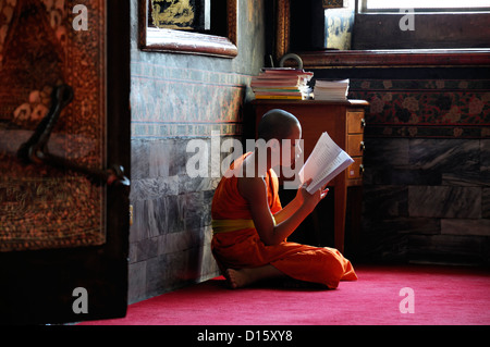 Orange derubato robe monaco Wat Pho tempio del Buddha reclinato santuario buddista di Bangkok in Thailandia Foto Stock