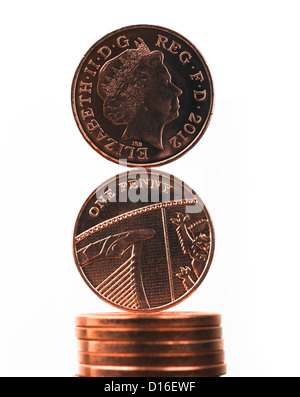 British un penny monete decimali bilanciato sulla parte superiore della pila di monete contro uno sfondo bianco. Credito: Malcolm Park/Alamy. Foto Stock