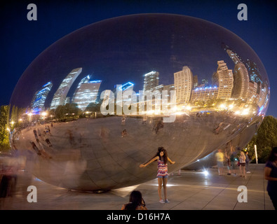 Portando il mondo sulla schiena. Un grazioso modello a Cloud Gate (Il Bean) di notte in Millennium Park di Chicago, Illinois. Foto Stock